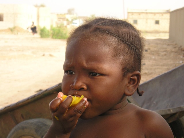 Una bimba mangia il mango
